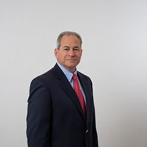 Head shot of a caucasian man standing in front of gray background